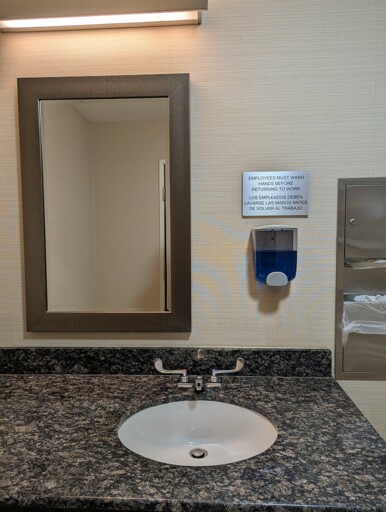 A bathroom sink with the mirror considerably off center